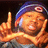 A pixelated image shows a person wearing a blue beanie with a white circular logo, making a hand gesture with one finger raised and the other hand forming a shape near their face, set against an orange background with green text.