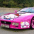 A pink sports car with a light blue roof is shown on a road with greenery in the background, next to bold white text on a bright pink background.