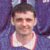 Static pixelated image of a person with short dark hair wearing a white sleeveless top against a purple background.