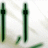 Animated green pen icons with subtle motion on a light background, showing slight shifts in position and orientation across frames.