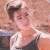 A pixelated image of a person with light hair in an updo wearing a sleeveless top, next to green text reading 'Original Icons .com' on a dark background.