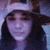 A person with long dark hair wearing a light-colored headband and wide-brimmed hat, shown in three sequential poses against a blurred background.