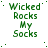 Green pixelated text 'Wicked Rocks My Socks' repeated in a pattern on white background with scattered green dots