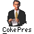 Pixelated image of a person in a black suit with a white shirt and gold tie, holding a white object, with text below reading "Coke Pres".