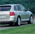 Pixelated image of a light-colored sedan with a red taillight, positioned on a grassy area with a blurred background.