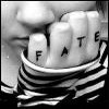 Black-and-white close-up of a person's hand with fingers spelling 'FATE' in block letters, wearing a striped shirt, partially cropped at the edges.