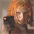 A pixelated image shows a person with light brown hair holding a black camera with an orange flash, against a neutral background.
