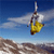 Static pixelated image of a parachutist in mid-air with yellow parachute against blue sky and brown terrain background.