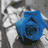 Four distinct colored roses—blue, purple, red, green—are arranged in a against a grayscale floral background with visible petals