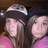 Two people in pink shirts and hats pose together under a dark background with pink text reading 'i love you.'
