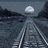 Pixelated grayscale image of a train track leading toward a distant horizon with a small cloud, surrounded by black background with white text.
