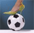 Static pixelated image of a soccer ball with a hand holding a yellow object above it against a blue background.
