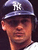 Pixelated image of a person wearing a dark blue baseball cap with white 'NY' logo, dark sunglasses, and light-colored shirt against dark background.