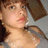 Pixelated close-up of a person with light skin tone, brown hair styled in an updo, and visible shoulder area.