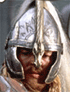 A close-up of a person wearing a silver helmet with intricate patterns and a central crest, long light-colored hair visible beneath the helmet.