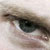 A close-up of a human eye with brown eyelashes and light skin tones, showing the iris and pupil in pixelated detail.
