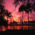 Pixelated static image of a sunset over water with dark silhouettes of trees and structures against warm pink, orange, and yellow hues.