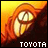 Pixelated image of a cartoonish character with glowing eyes and orange hair against a yellow-orange gradient background, featuring the text "TOYOTA" at bottom.