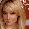 A static image of a person with long blonde hair and bangs, wearing a light-colored top, with a white decorative swirl on a brown background in the upper right corner.