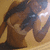 A pixelated figure with dark hair and light skin, wearing a brown top against a yellow background.
