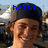 A pixelated image shows a person with brown hair wearing a dark cap, blue text reading 'hottie' overlaid at the top against a blurred outdoor background.