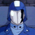 Pixelated blue and white character with large eyes, a white helmet-like top, and a light blue lower face, set against a blue background.