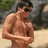 A pixelated image of a shirtless man with sunglasses on a beach, next to pink text reading 'sexy!!', 'xoxo', and 'kim c.'