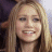 A static split-screen image shows a pixelated portrait of a smiling person with long light brown hair on the left and green text reading 'OriginalIcons.com' on a dark green background on the right.