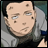 Pixelated close-up of a character with light skin, dark hair, and multiple brown spots on the face wearing a gray shirt.