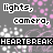 Pixelated text repeats 'lights, camera,' and 'HEARTBREAK' across a gray background with pink speckles; some words shift color from white to pink.