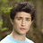 Pixelated image of a person with dark hair in a light blue shirt against a blurred green background, with cyan text on a purple background reading "Matt Dallas!!" and "I Love Kyle XY".