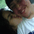 Pixelated close-up of two figures in intimate embrace, one with light brown hair and the other with dark hair, against a blurred background.
