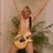 Pixelated figure holding a guitar, wearing sleeveless top and dark pants against muted background.