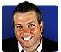 A pixelated close-up of a person with short dark hair wearing a black jacket over a white shirt against a solid blue background.