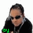 A person with dark hair and sunglasses wears a black shirt and silver chain, with green text below them changing from 'oy' to 'boy' across frames.
