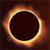 A circular dark center surrounded by a glowing ring of orange, yellow, and white pixels on a dark brown background.