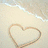 Beach scene with heart drawn in sand and turquoise text fragments on light background.