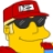 Pixelated yellow cartoon character wearing red cap with white 'M' logo and black sunglasses, smiling with closed eyes.