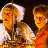 Pixelated static image of two characters from Back to the Future in orange and white tones with dark background.