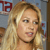 A pixelated close-up of a person with long blonde hair, light skin, and a dark choker necklace, set against a blurred background with red and blue elements.