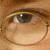 Static close-up of a human eye with brown skin tone, visible eyelashes, and subtle facial features in low-resolution pixel art style.