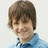 Pixelated portrait of a person with brown hair and a blue shirt against a light background.