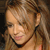 A pixelated close-up of a person with light brown hair, wearing a dark choker necklace, and a light-colored top with a visible orange strap.