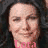 Pixelated close-up of a person with light skin, dark hair, and closed eyes wearing pink clothing against a dark background.