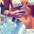A pixelated image of a person holding a blue patterned bag, with visible hands and torso in warm tones.