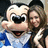 Pixelated image of a cartoon mouse character with large ears and a blue outfit standing next to a person with long brown hair.