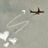 A pixelated static image shows a dark brown airplane flying left to right above white cloud shapes against a light gray background.