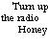 Pixelated text and a radio icon on a white background with a gray rectangle in the bottom right corner.