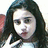 Pixelated static image of a person with long dark hair, light skin tone, and visible facial features including eyes, nose, mouth, and eyebrows.