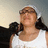 Pixelated image of a person with light brown hair wearing a white tank top and dark jacket draped over shoulders against gradient background.